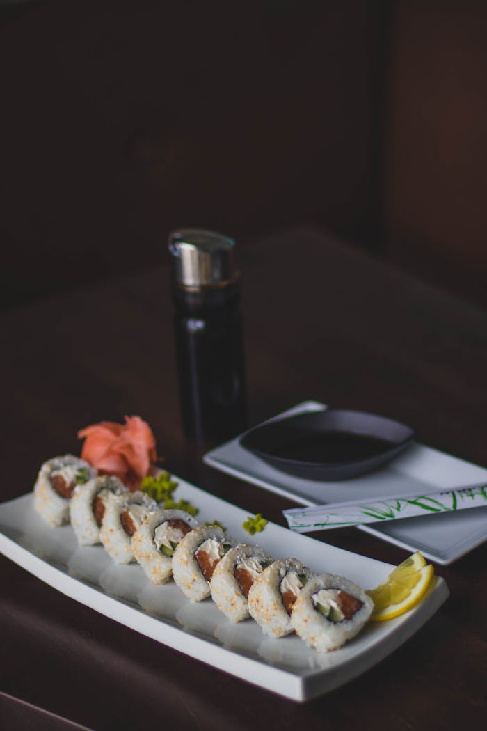 services-03 Tasty sushi rolls served with soy sauce, ginger, and wasabi on a dark background.